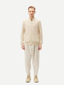 Cream-colored zip-up cashmere sweater on a light gray background #color_off-white