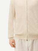 Cream-colored zip-up cashmere sweater on a light gray background #color_off-white