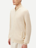 Cream-colored zip-up cashmere sweater on a light gray background #color_off-white