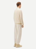 Cream-colored zip-up cashmere sweater on a light gray background #color_off-white