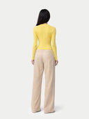 Person wearing a yellow sweater and beige pants on a white background. color_vivid-yellow #ai-image
