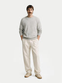 Man wearing a light gray cashmere sweater and beige pants on a white background.  #color_steel_silver