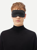 A man wearing the charcoal cashmere eye mask with a black turtleneck, front view.
