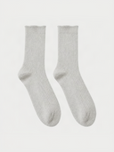 A pair of warm light cashmere rib-knit socks laid flat against a light gray background.