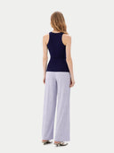 Woman wearing a navy sleeveless top and light gray wide-leg pants on a white background #color_dark-indigo
