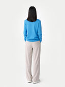 Person wearing a blue sweater and beige pants on a white background.  #color_cendre-blue