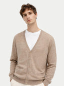 A man wearing a light brown knit V-neck cashmere cardigan over a white t-shirt, photographed against a solid light gray background. #color_taupe