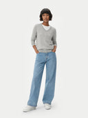Person wearing a gray cashmere sweater and light blue jeans on a white background. #color_steel-silver