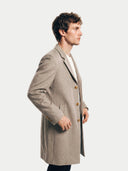 Model wearing the Men's Cashmere Coat with Notched Lapels in Taupe, three-quarter side view
