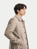 Model wearing the Men's Single-Breasted Cashmere Coat in Taupe, three-quarter side view