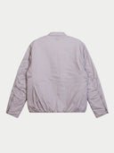 A light lavender-gray puffer jacket shown from the back, featuring a quilted design and elasticated hem, photographed against a solid off-white background.