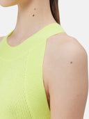 A woman wearing a sleeveless cashmere top in green.#color_lime-yellow