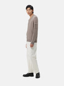 A gray knit zip-up cashmere bomber with a V-neck, ribbed cuffs and hem, and a sleeve pocket, shown against a light gray background. #color_cool-gray