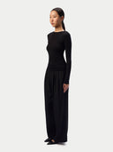 Model in the Black CashmereTech Ultralight Jersey with wide black trousers, three-quarter side view