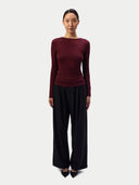 Model wearing the CashmereTech Ultralight Jersey in Zinfandel, a fitted boat-neck long-sleeve top, front view