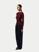 Model in the Zinfandel CashmereTech Ultralight Jersey with wide black trousers, three-quarter side view