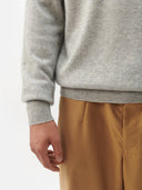 A light gray heather knit crewneck cashmere sweater with long sleeves and ribbed cuffs, displayed against a light gray background. #color_steel-silver