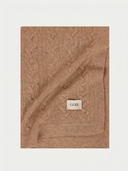 Cable knit cashmere blanket in Tannin Brown, folded, showing the cable texture and GOBI label.