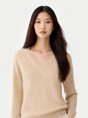Woman wearing a beige cashmere sweater against a white background. #color_beige