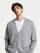 Man wearing a gray cardigan over a white shirt on a light gray background