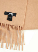 close up of an almond color fringed scarf with label "GOBI","100% cashmere"