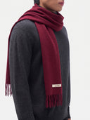 Model wearing the Cashmere Woven Scarf in Bordeaux around the neck, side view