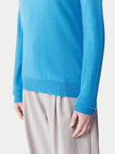 Person wearing a blue sweater and beige pants on a white background.  #color_cendre-blue