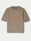A taupe short sleeve top with a brand logo on a white background