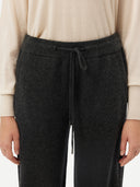 A pair of dark charcoal gray knit wide-leg pants with a drawstring waist, shown flat against a light gray background. #color_charcoal