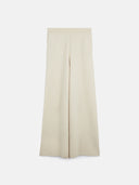 A pair of wide-leg trousers in a light beige or cream color, shown flat against a solid light gray background. #color_off-white