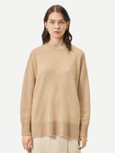 A woman wearing a beige loose-fit cashmere sweater. #color_beige