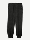 A pair of charcoal women's cashmere joggers with a ribbed hem and elastic waistband. #color_charcoal
