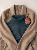 Blue cashmere long-sleeve polo shirt with a GOBI label, holding two notebooks under one arm