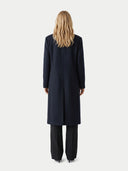 back view of a person wearing a long black coat on a white background.