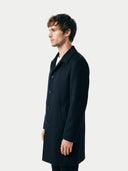 Man wearing a black coat against a white background