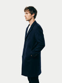 Man wearing a dark blue coat against a white background