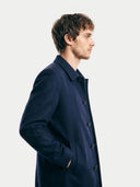 Man wearing a navy overcoat on a white background