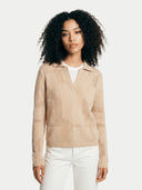 Woman wearing a beige knitted sweater and white pants on a light background. #color_beige