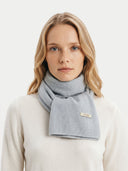 Woman wearing a light gray scarf with a visible brand logo on a white background.