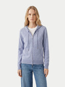 close up front view of a woman wearing a light blue zip-up hoodie on a white background.