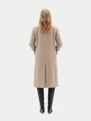 back view of a person wearing a beige coat on a white background.