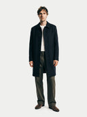 Man wearing a dark navy coat on a white background