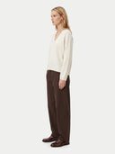 Cardboard cutout of a man in a gray sweater and dark pants on a white background