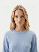 Women's Light Blue Cashmere Crewneck Sweater worn by model, detail view on white background