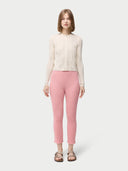 A woman wearing pink rib-knit cashmere silk pants with a pair of sandals.#color_icing-pink