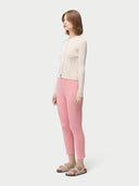 A woman wearing pink rib-knit cashmere silk pants with a pair of sandals. #color_icing-pink