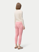 A woman wearing pink rib-knit cashmere silk pants with a pair of sandals. #color_icing-pink