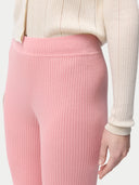 A woman wearing pink rib-knit cashmere silk pants . #color_icing-pink