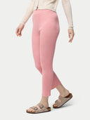 A woman wearing pink rib-knit cashmere silk pants with a pair of sandals.#color_icing-pink