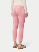 A woman wearing pink rib-knit cashmere silk pants with a pair of sandals.#color_icing-pink